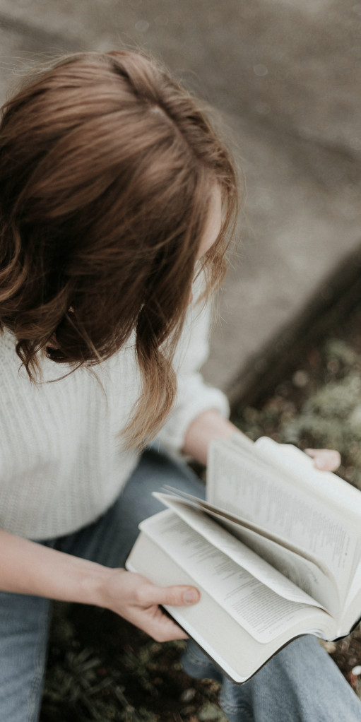 Junge Frau die bei einer Auszeit im Retreat Bibel liest.